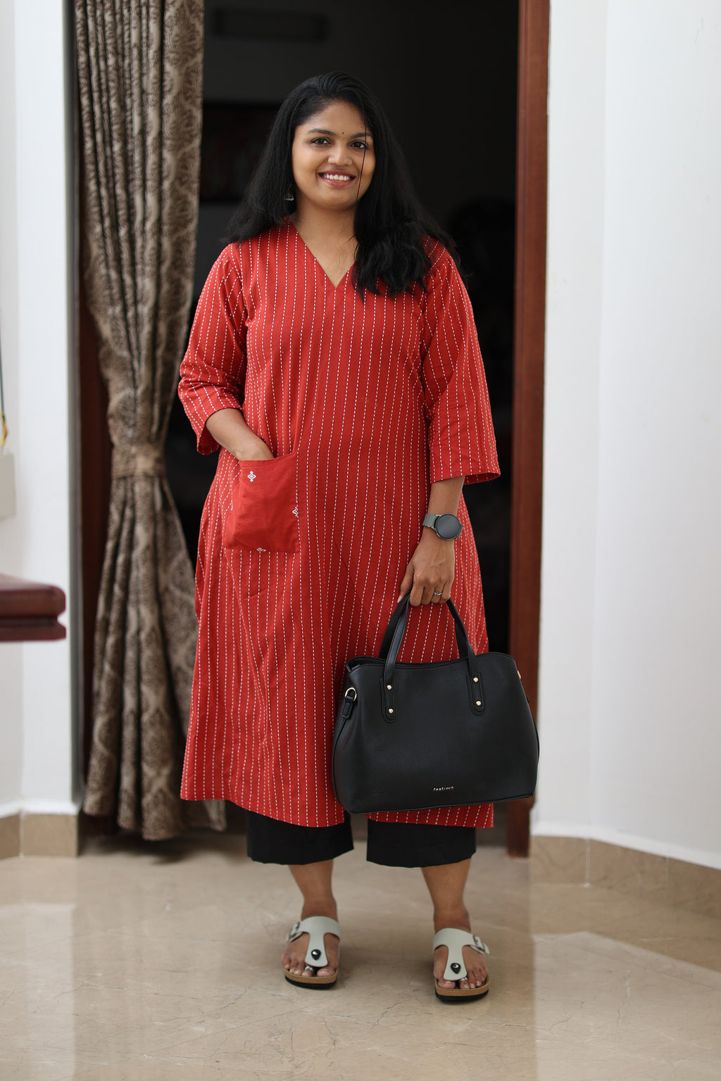30+ woman wearing a red striped office kurta, full front view