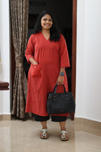 30+ woman wearing a red striped office kurta, full front view