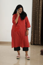 30+ woman using a phone in a red office kurta with statement pocket