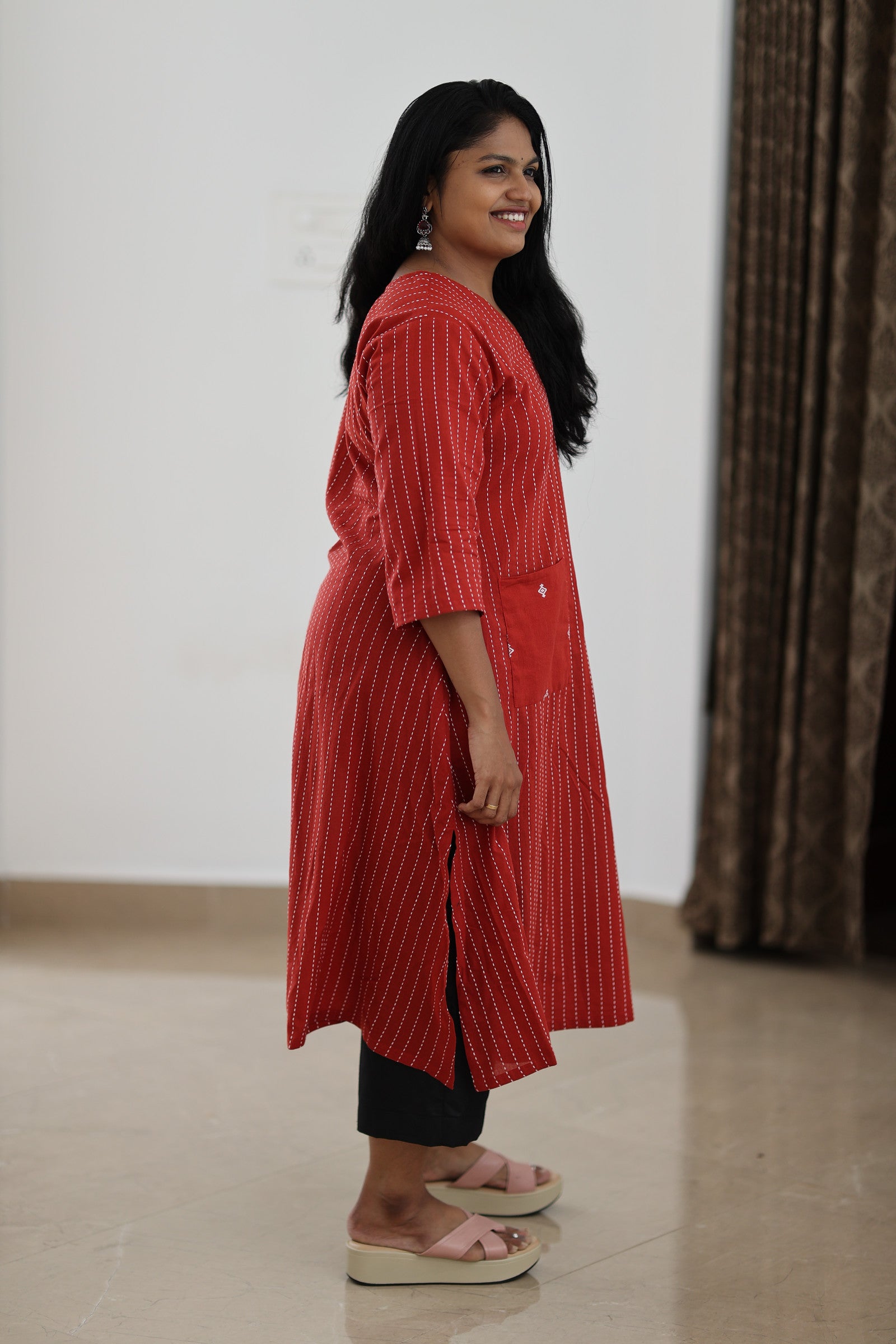 Side view of red striped longline office kurta showing length and slit