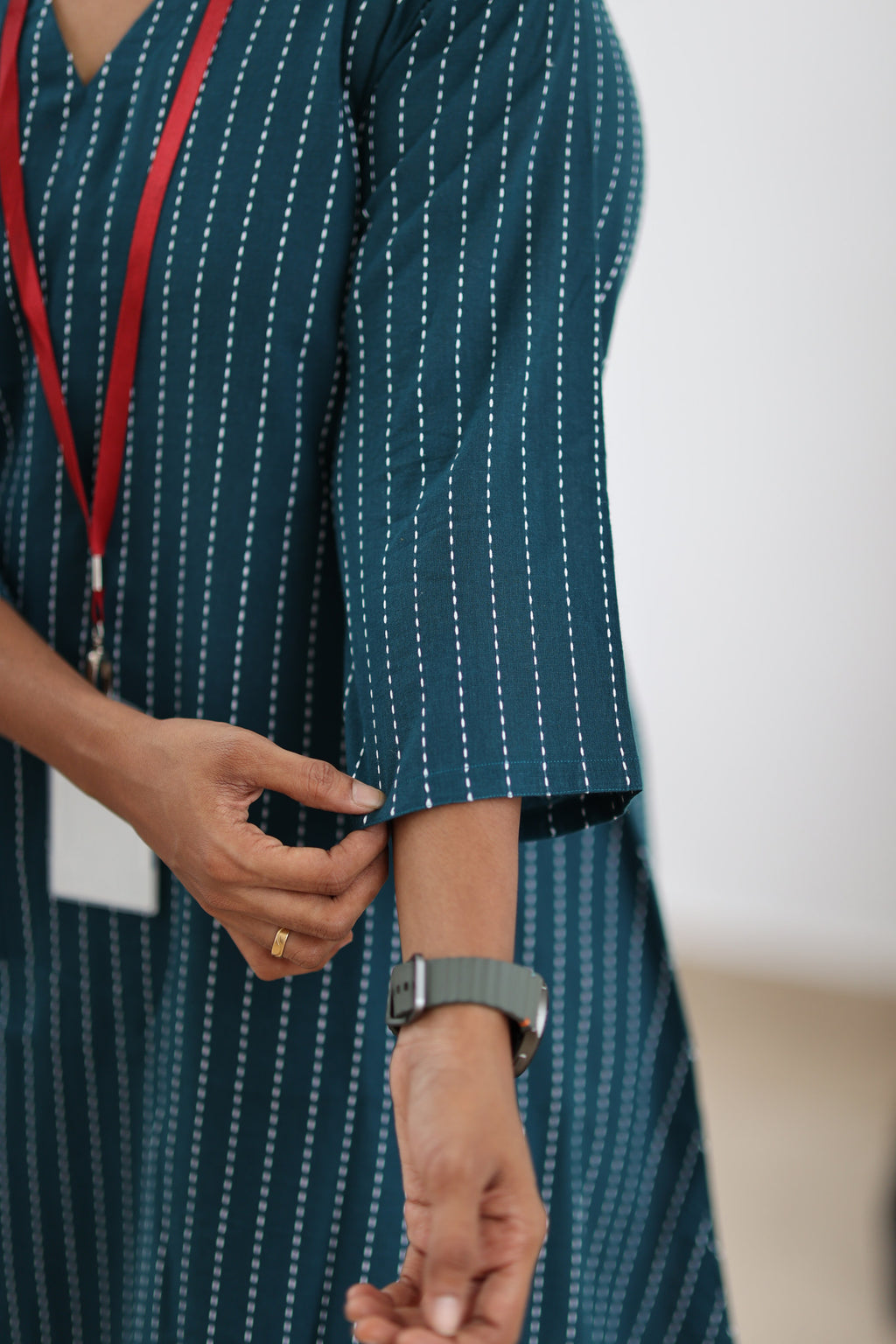 Three-quarter sleeve detail on teal striped office kurta