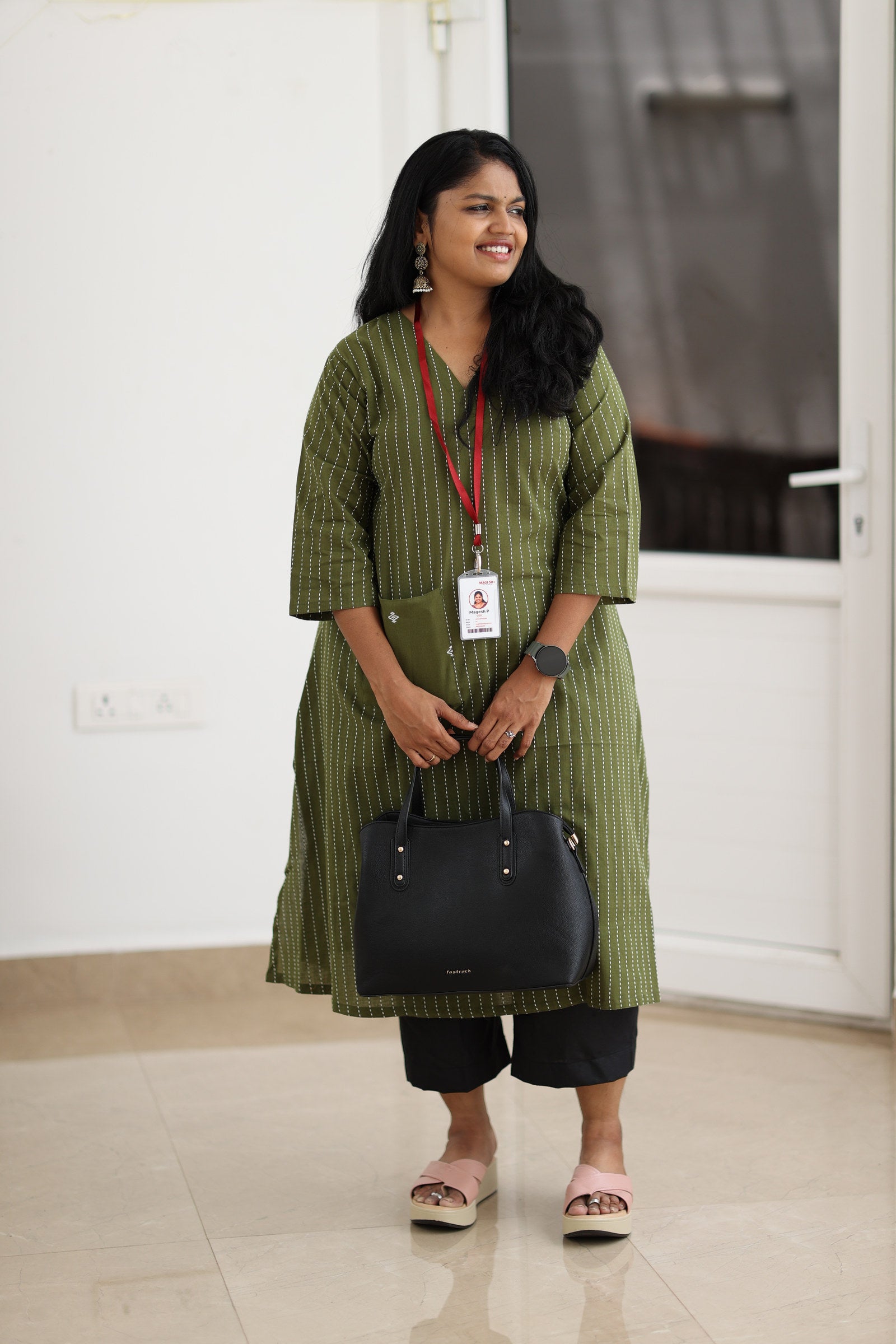 30+ woman wearing olive striped office kurta with black trousers and work bag