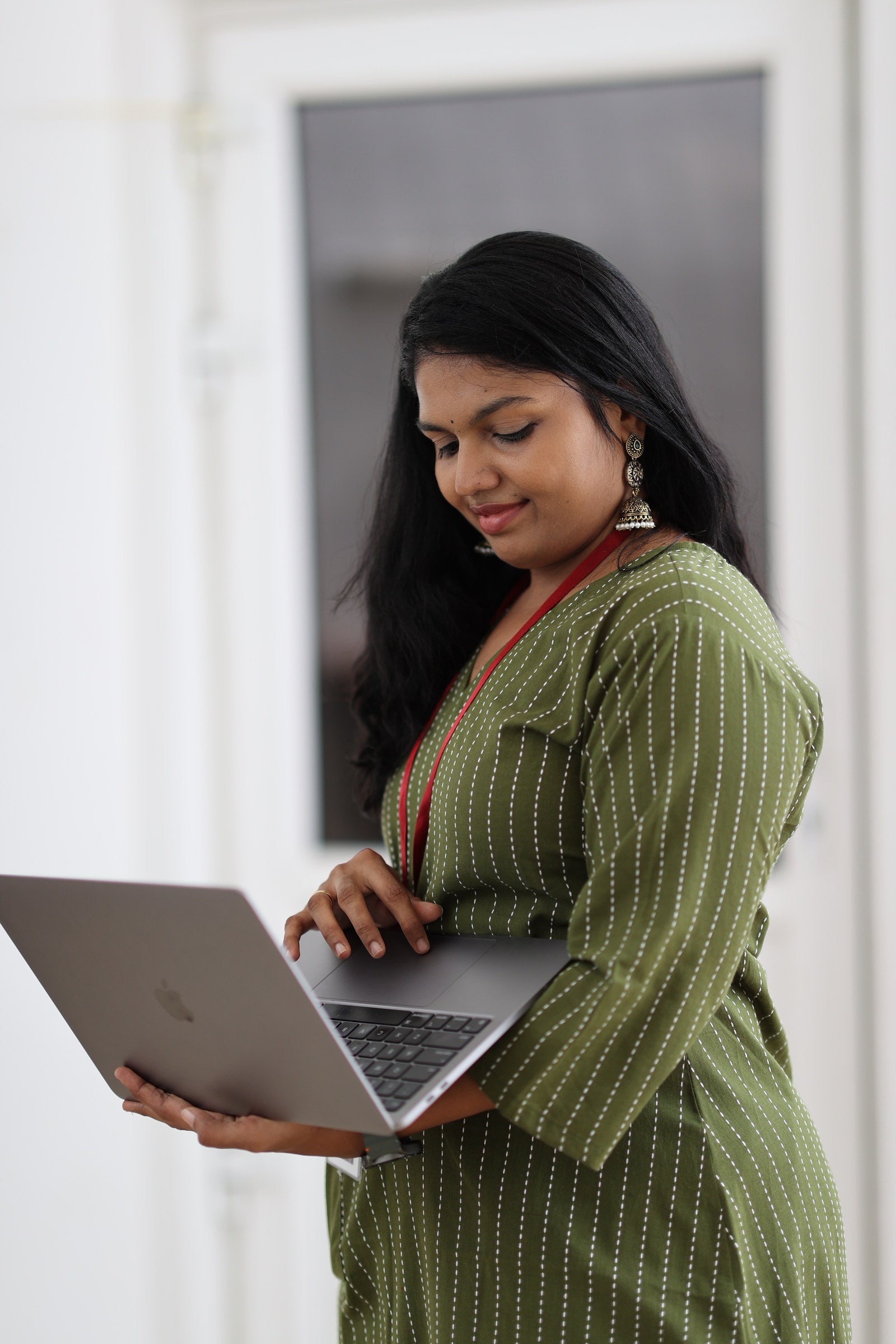 30+ woman working with laptop in olive striped office kurta
