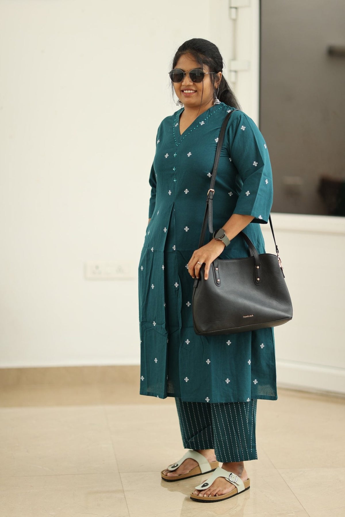 Deep teal kurta set styled with handbag