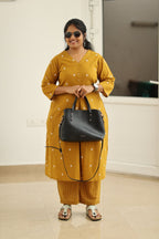 Amber gold kurta set styled with handbag