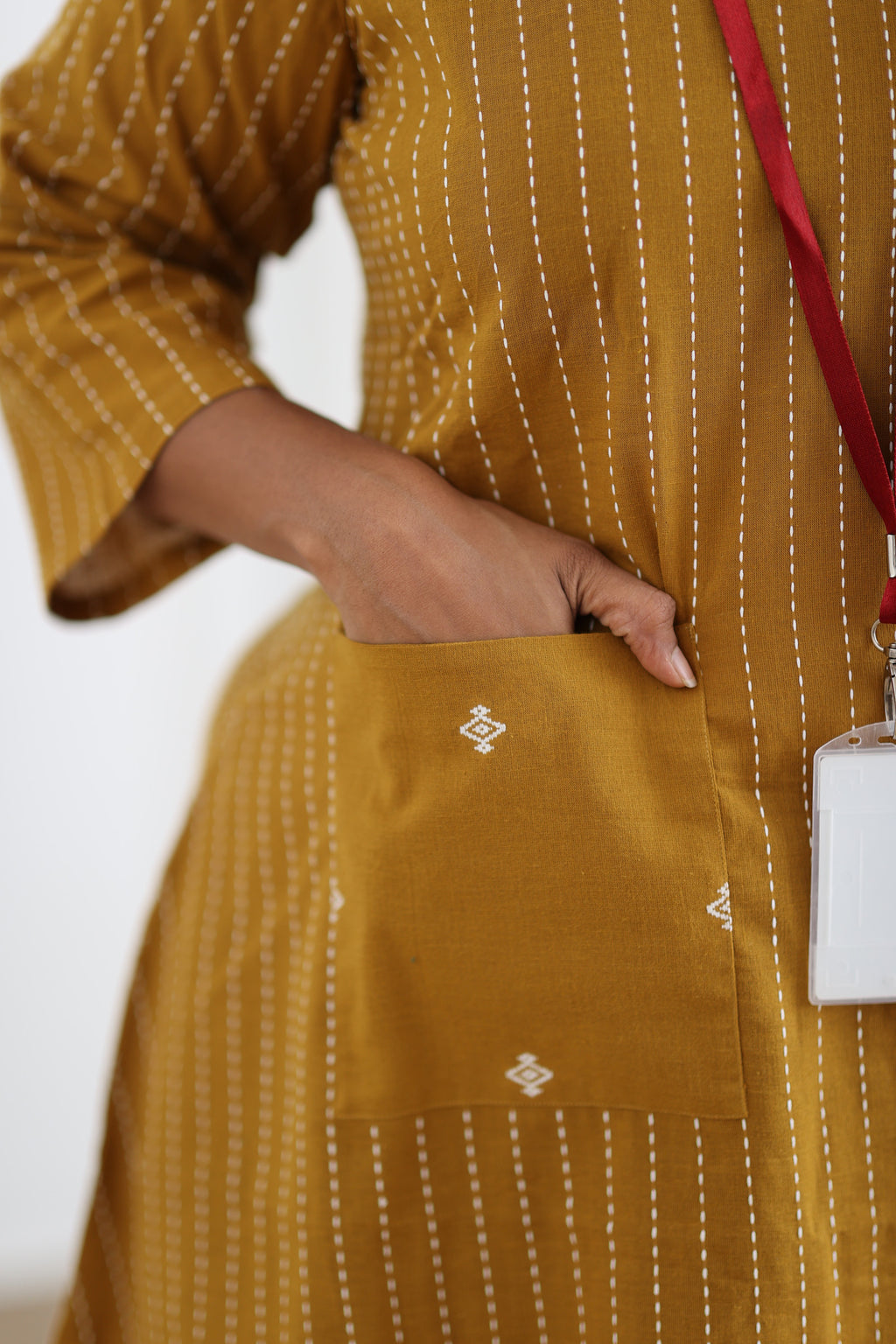 Close-up of contrast patch pocket on mustard striped kurta